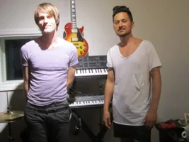 Two adult musicians, including student Oli and teacher Andrew, standing in a Brooklyn recording studio.