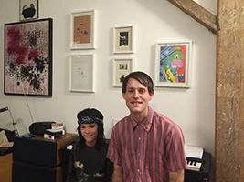 Piano teacher Andrew with his student Hunter smiling beside a keyboard in a Brooklyn apartment.