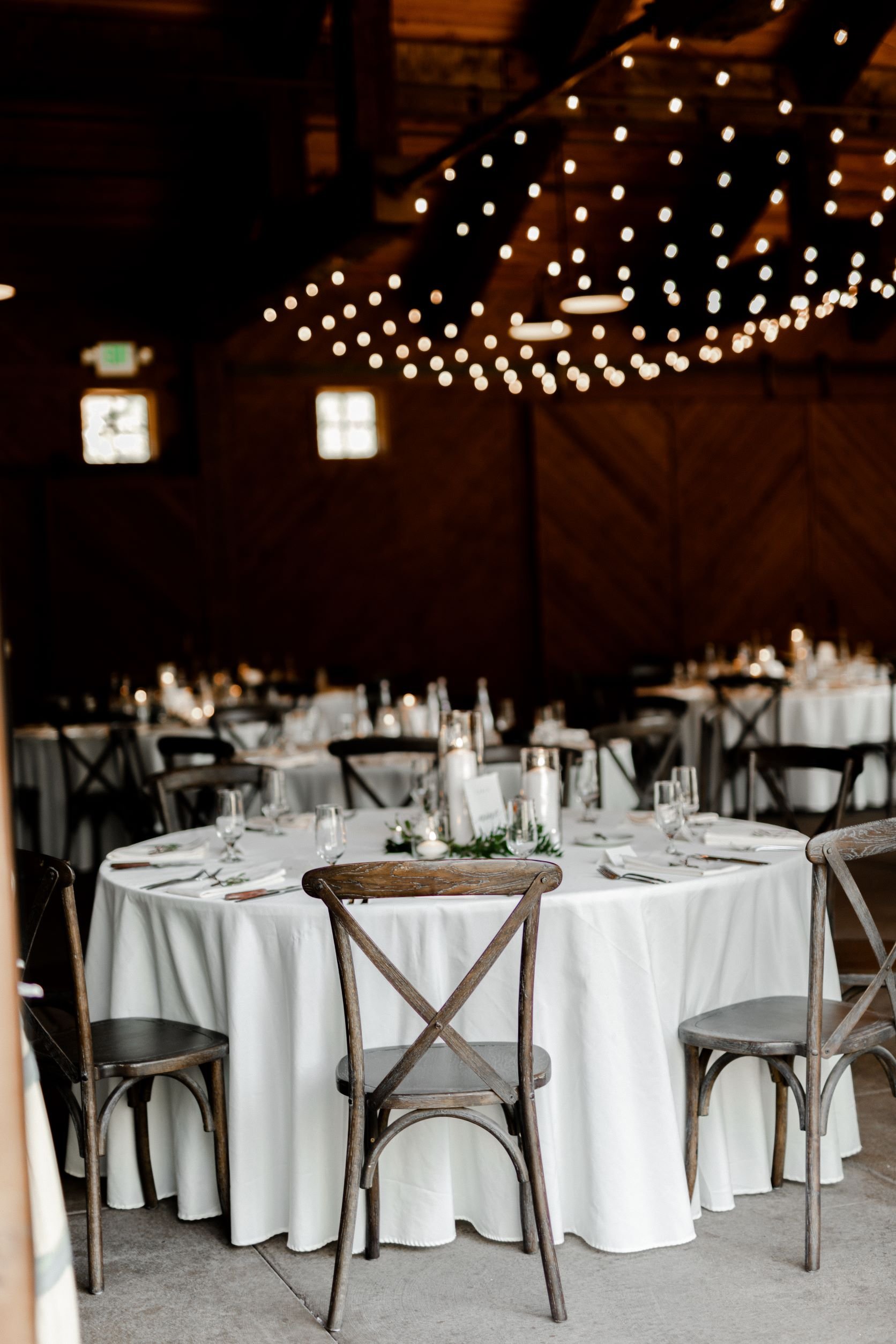indoor-swiftwater-cellars-wedding-reception-with-vineyard-chairs-and-string-lights