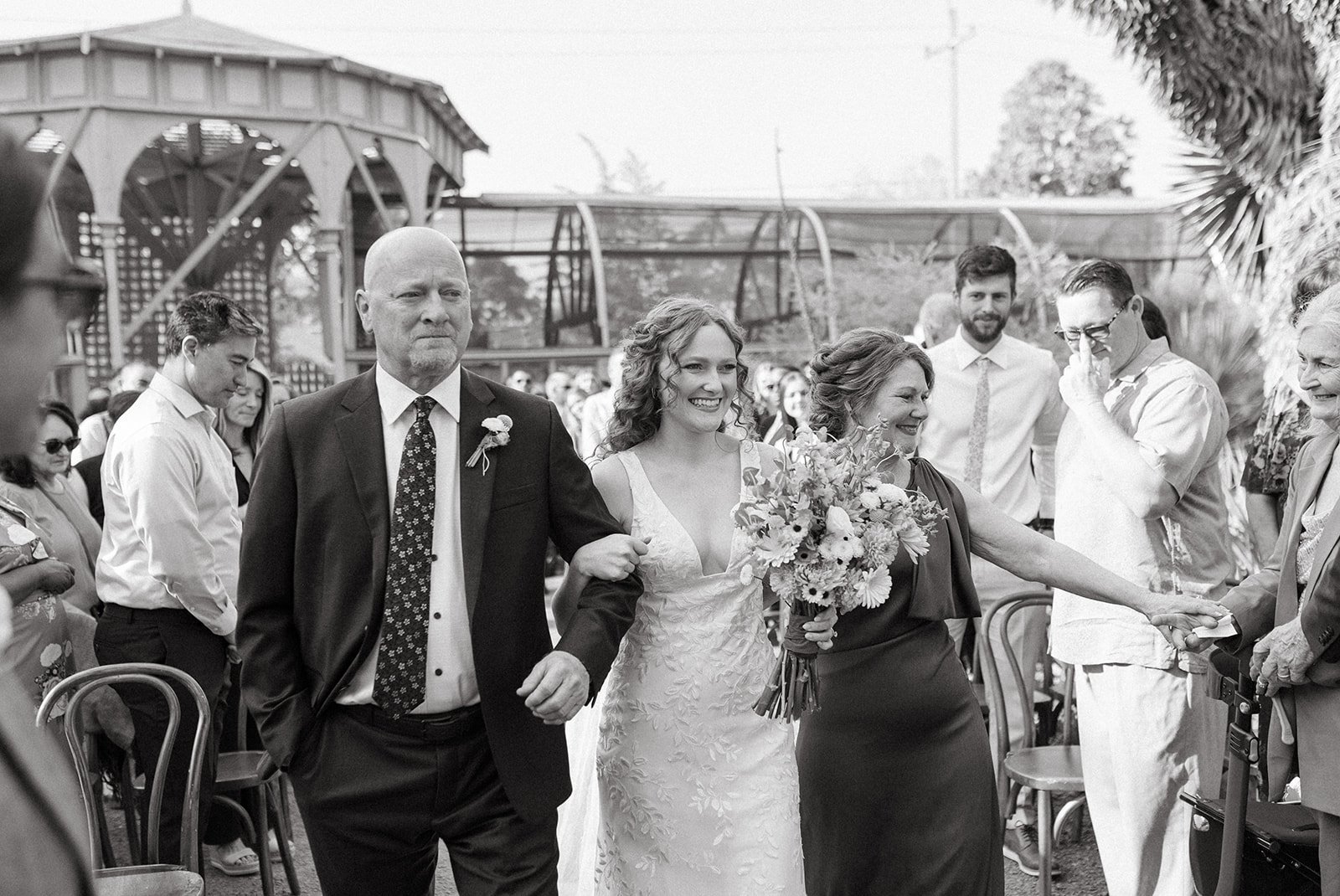 pacific-engagements-ruth-bancroft-gardens-wedding-photos-bride-and-parents-walk-down-ceremony-aisle-together-sam-minter-photography