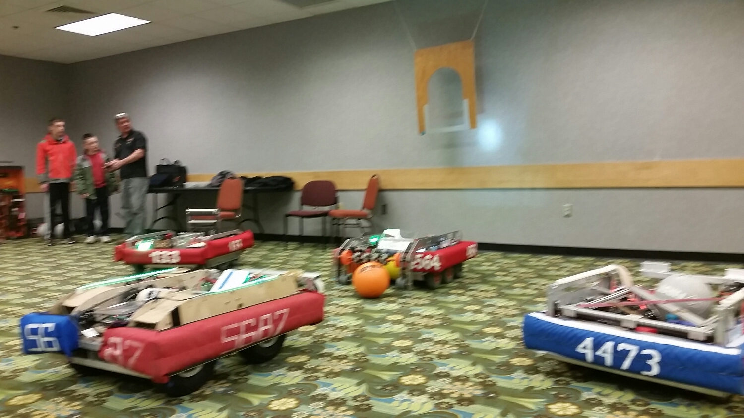 Stronghold robots from Delta Prime, Orange Chaos, and the Outliers take turns shooting