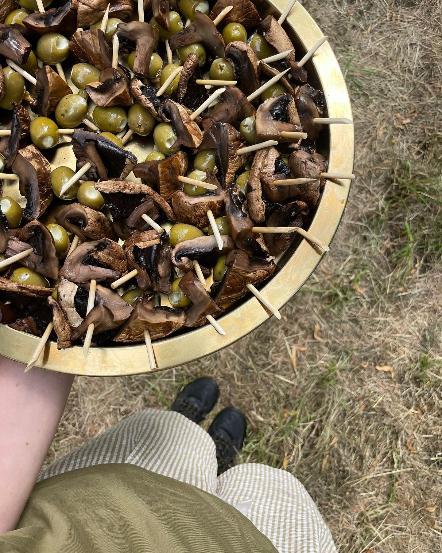 In the woods. 
At a festival. 
Cooked on fire. 
150 people at a time.