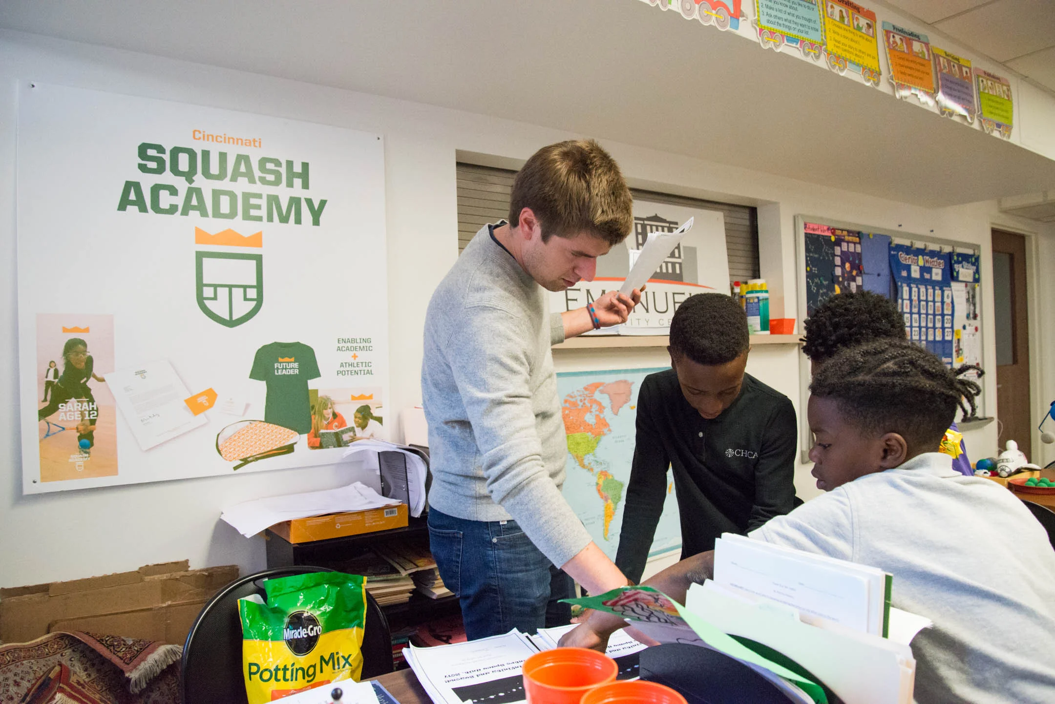 Austin Schiff, executive director of the Cincinnati Squash Academy, hands out papers and academic work to students at the Cincinnati Squash Academy. The program incorporates an emphasis on education in addition to athletics.