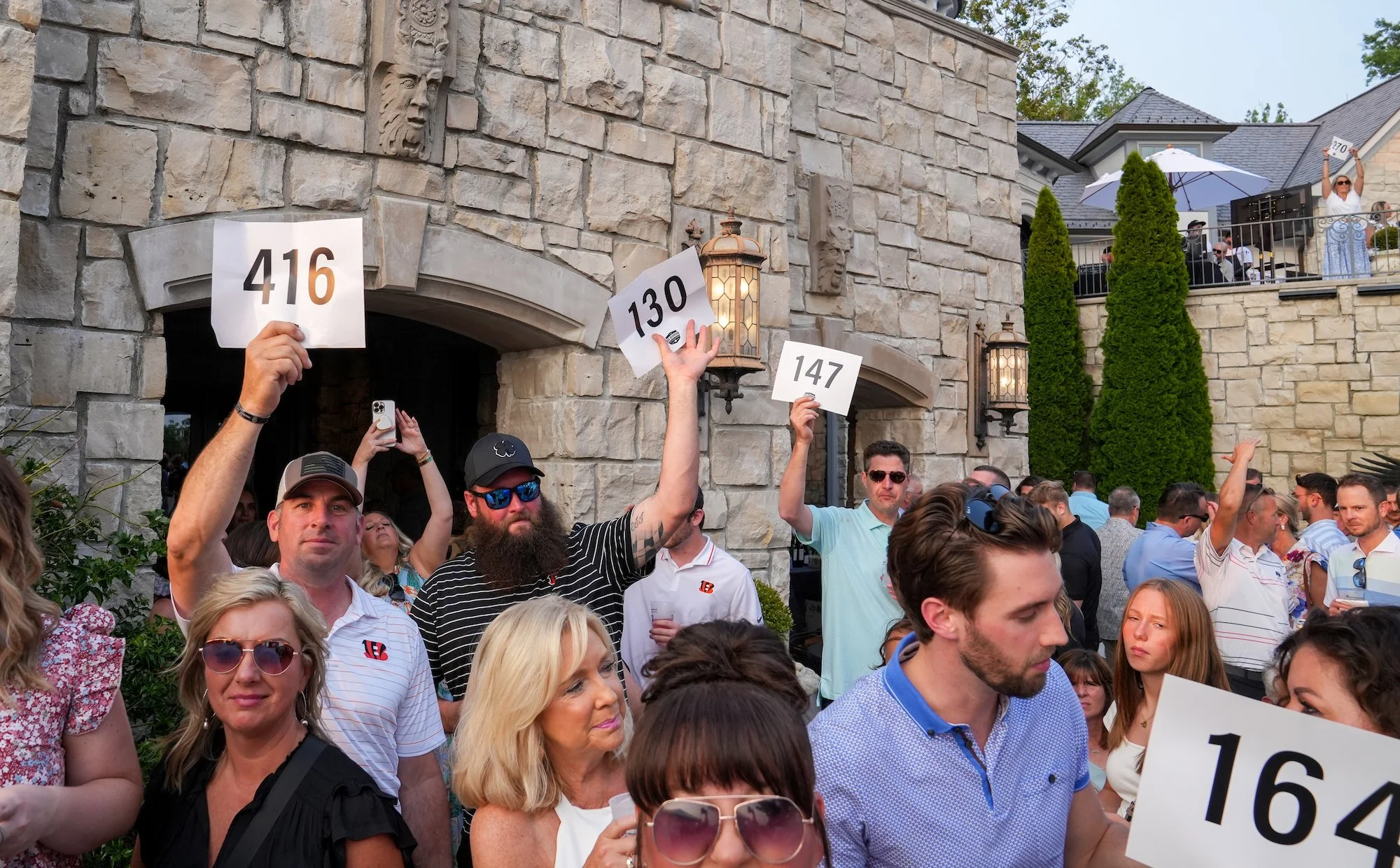  Bidders raise their paddles during the live-auction at the after party of the Inaugural Joe Burrow Foundation Golf Invitational Monday, June 5, 2023. Nearly one million dollars was raised to provide resources and support to the underprivileged and t
