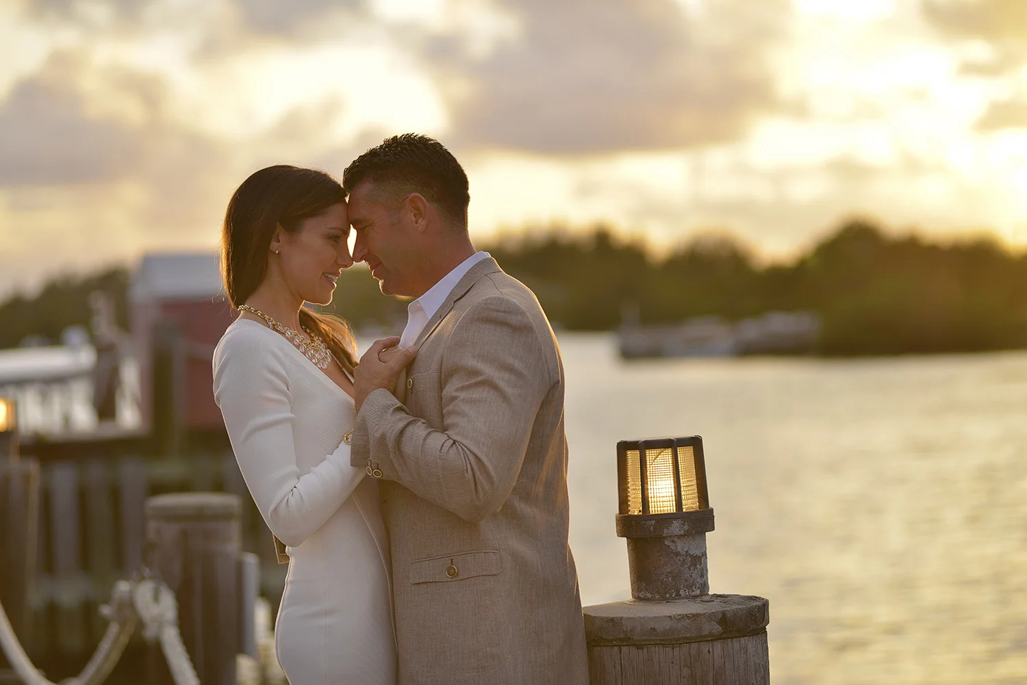 Couple slow dancing at sunset by the ocean.