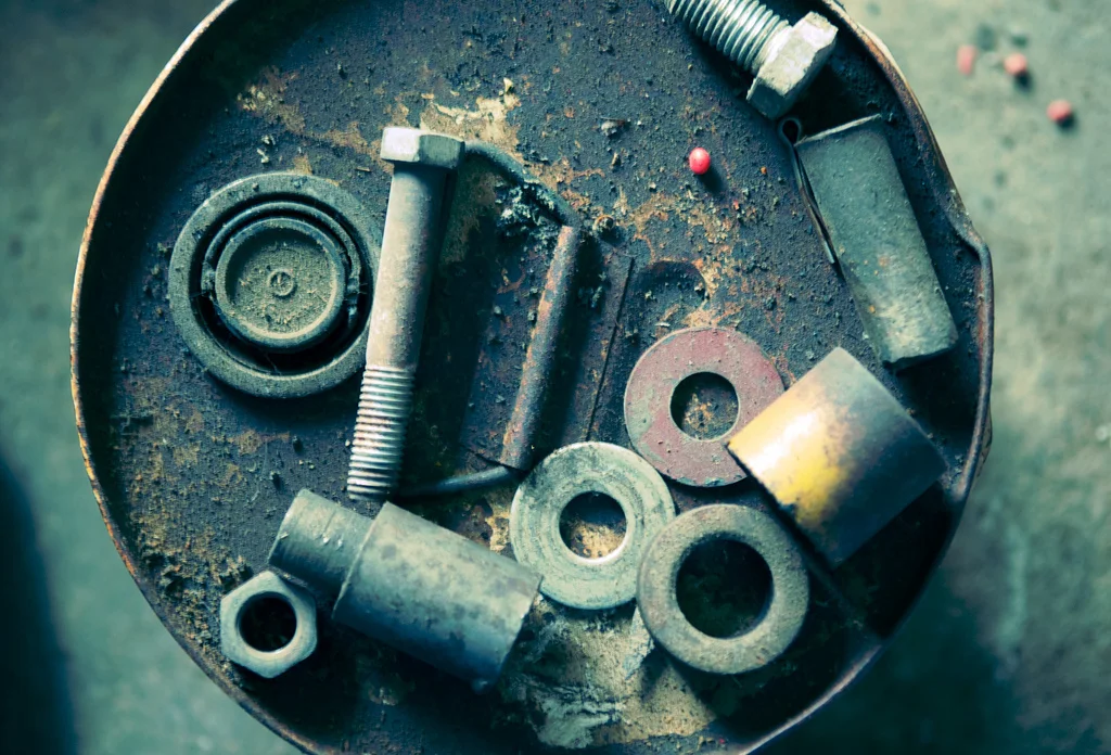 Nuts, bolts and washers collect dust on the top of a bucket in a barn near Clarinda, Iowa. Farm Relic 001.