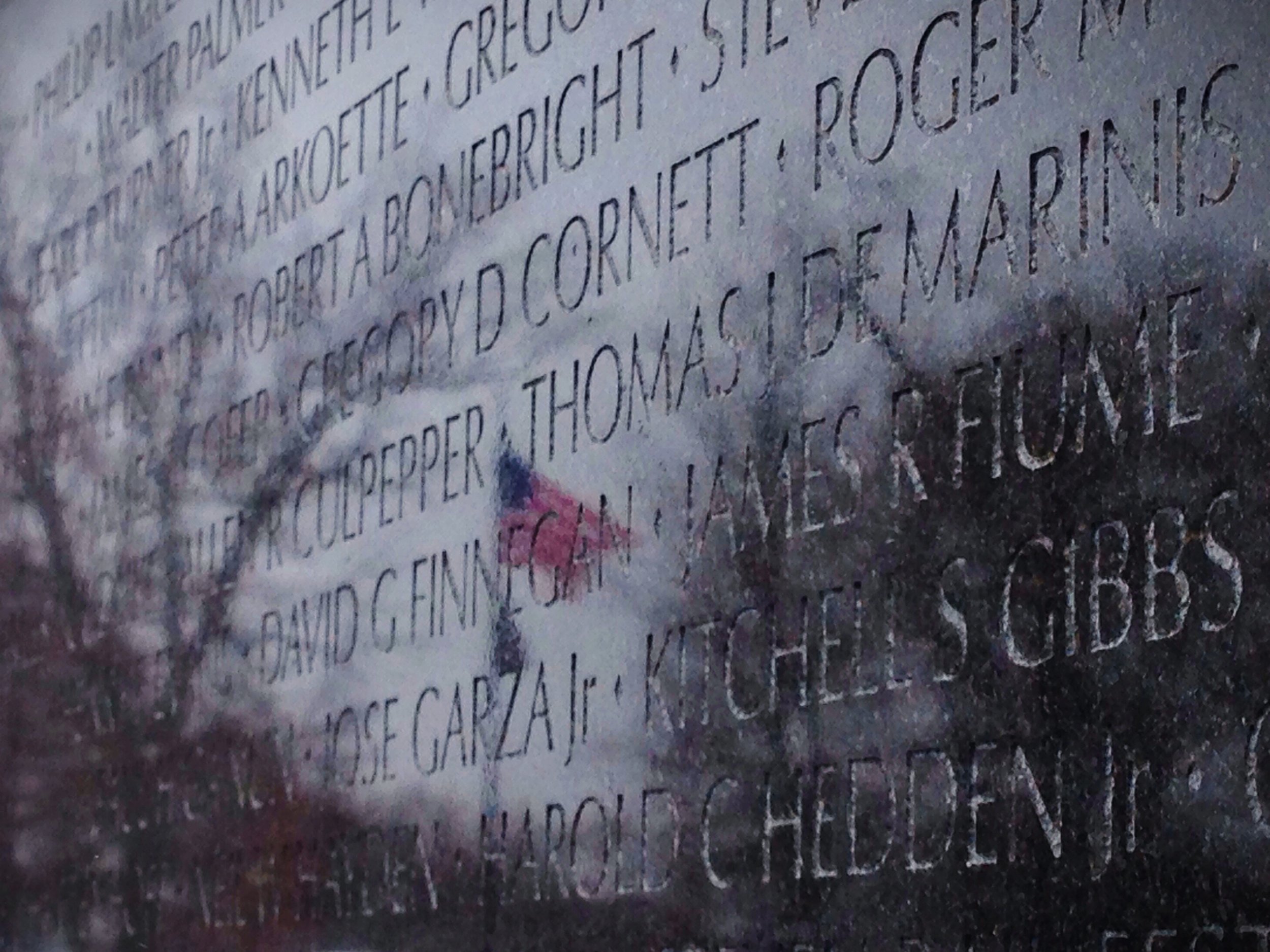 The American flag is reflected in the Vietnam Memorial in Washington, D.C.