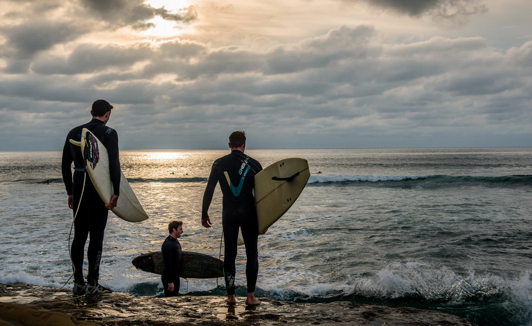 Surfers pause to judge the waves before making their way into the surf.