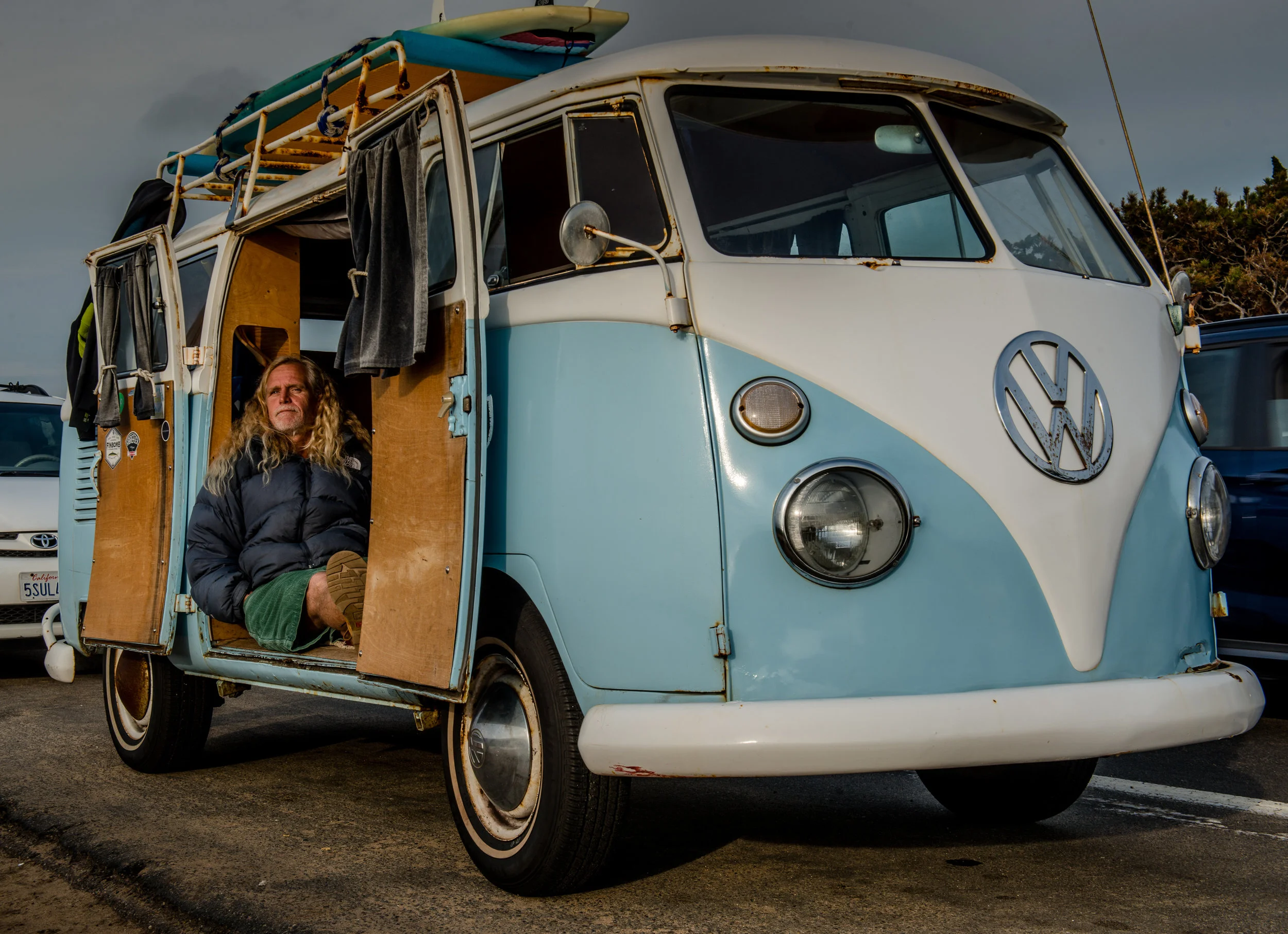 Richard Aguirre relaxes in his vintage Volkswagen van while enjoying the last rays of the sun on Sunset Cliffs Boulevard in Ocean Beach, California.