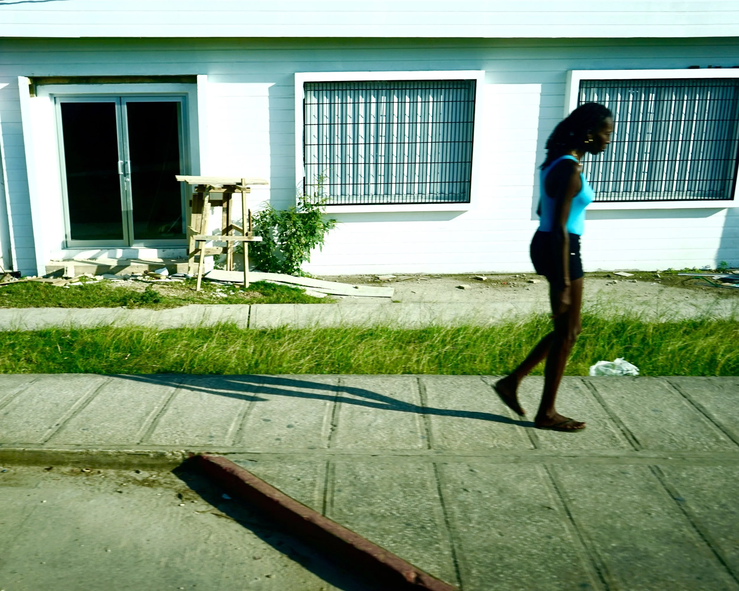A woman walks along the road in Belize City, Belize.