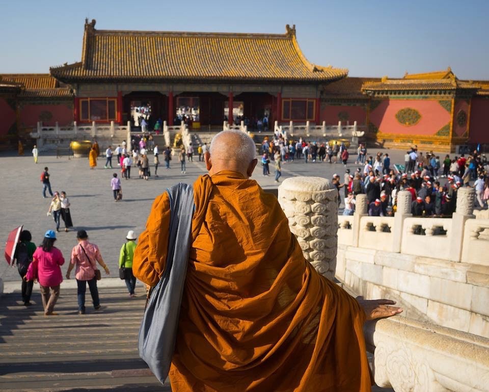 A monk walks down the stairs at the entrance of the Forbidden City in Beijing, China.   