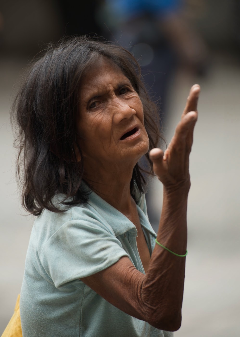  A woman begs for charity outside of a Catholic Church in Manilla, Phillipines.   