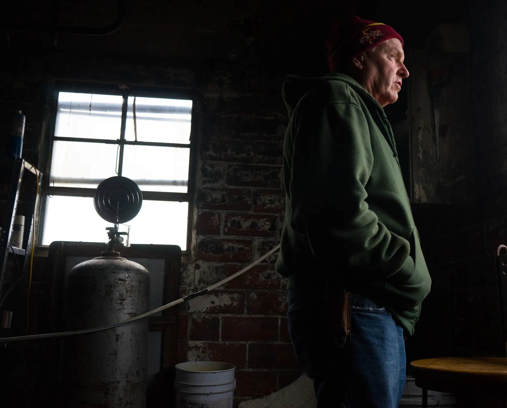 Morey Hill looks out of a window in his barn to check his flock. (Photo: Joseph L. Murphy)