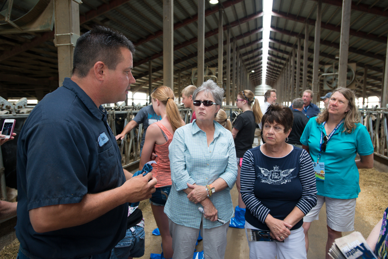 A farmer describes the milking process to visitors. (Photo: Joseph L. Murphy)