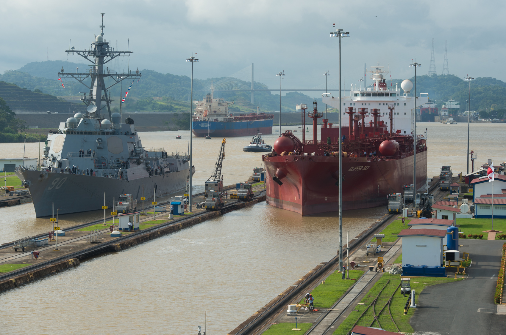 A U.S. destroyer and grain ship are pulled through the final locks of the Panama Canal. The expansion canal is ready to begin operations in 2016. (Photo: Joseph L. Murphy)