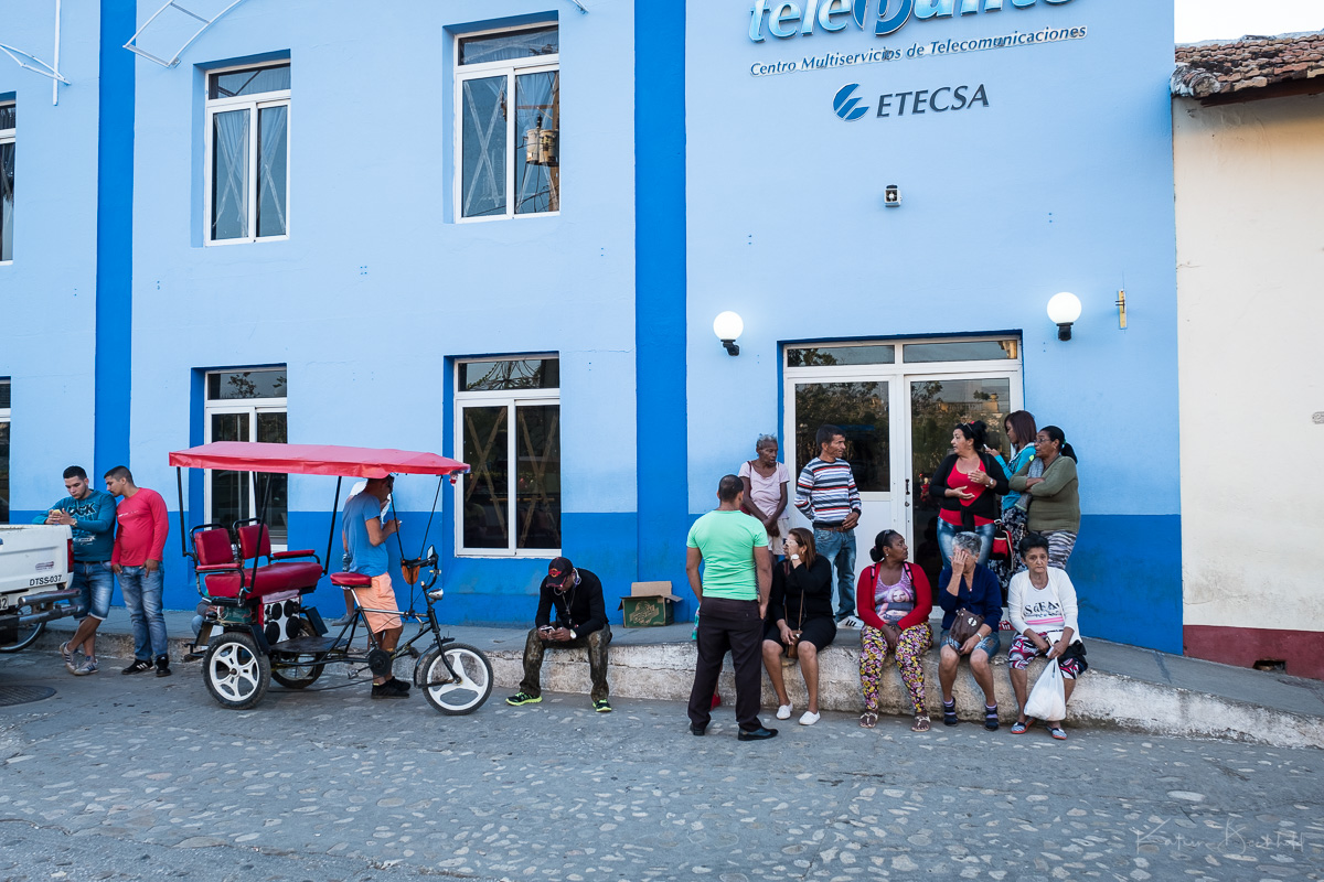 Schon in den frühen Morgenstunden warten die Menschen, dass das Etecsa-Büro aufmacht (und dann dürfen immer nur drei Menschen rein in die wunderbare Kühle der Aircondition - alle anderen bleiben draußen bei 35 Grad, egal wie lang die Schlange ist... dafür sorgt ein Herr in Uniform)