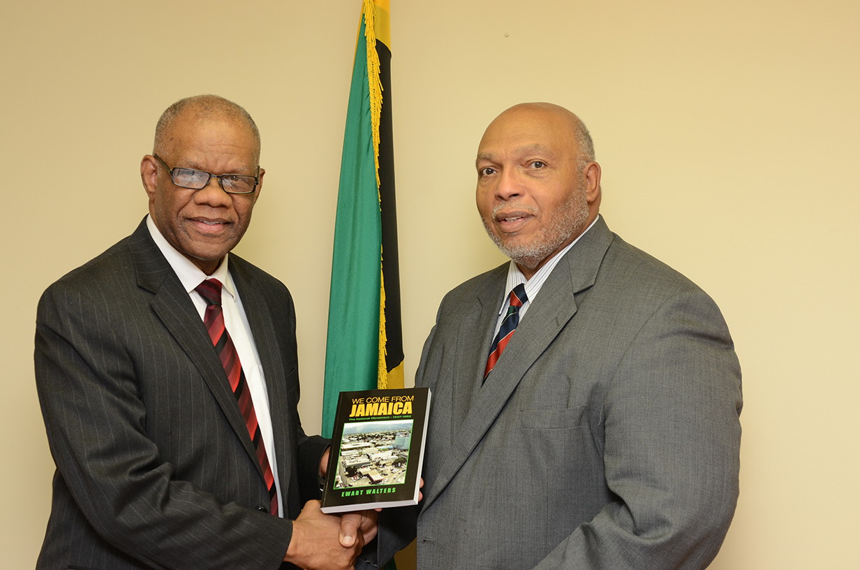 Ewart Walters (r) presents a copy of his new book to Jamaica's consul general George Ramocan