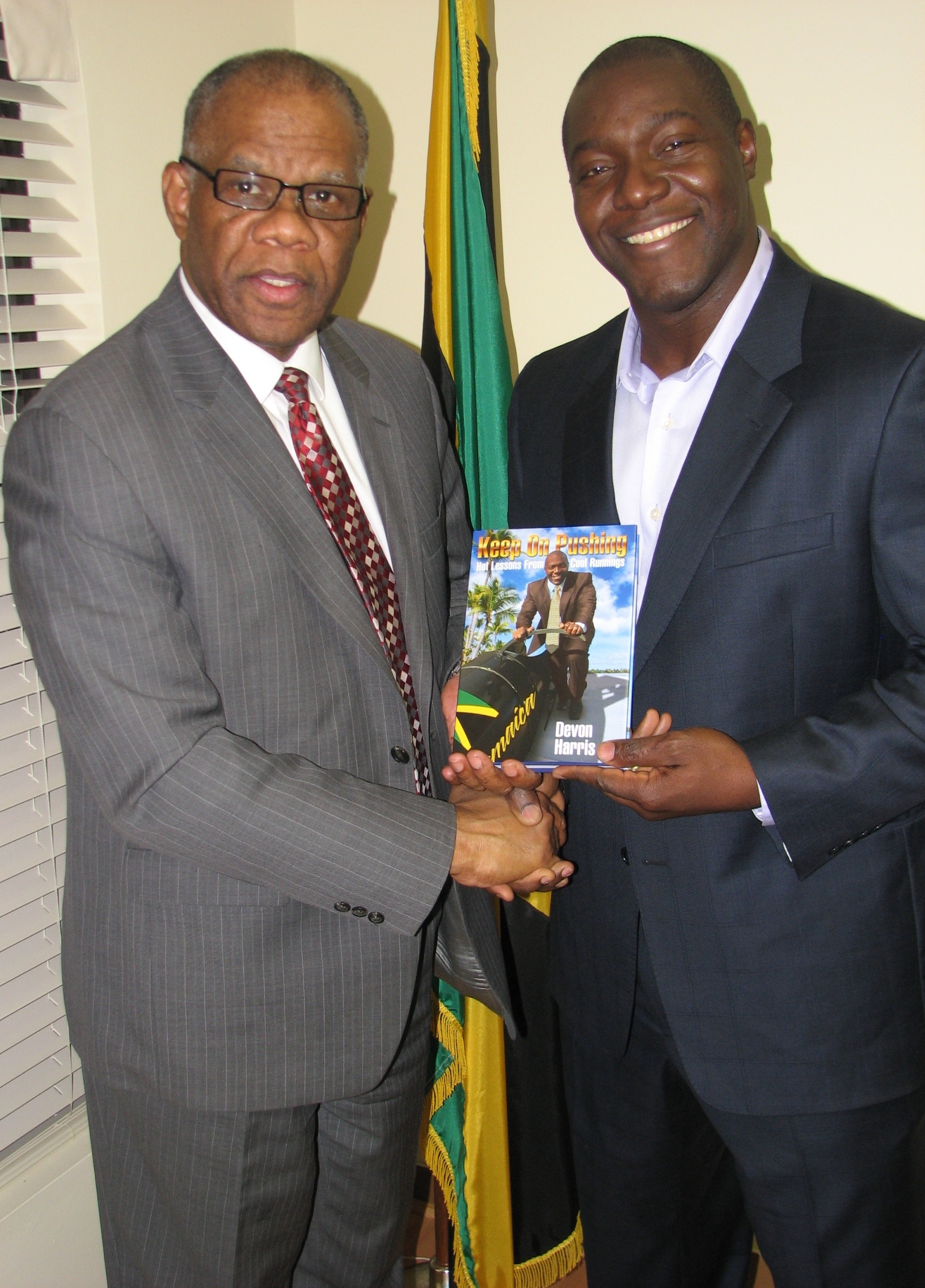 Devon Harris presents a copy of ‘Keep on Pushing: Hot Lessons from Cool Runnings’ to former Jamaica consul general to Toronto George Ramocan