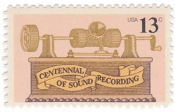 This quirky stamp uses ribbon as a background for the type to separate it from the illustration and make it stand out against the image. (via Mystic Stamp Company)