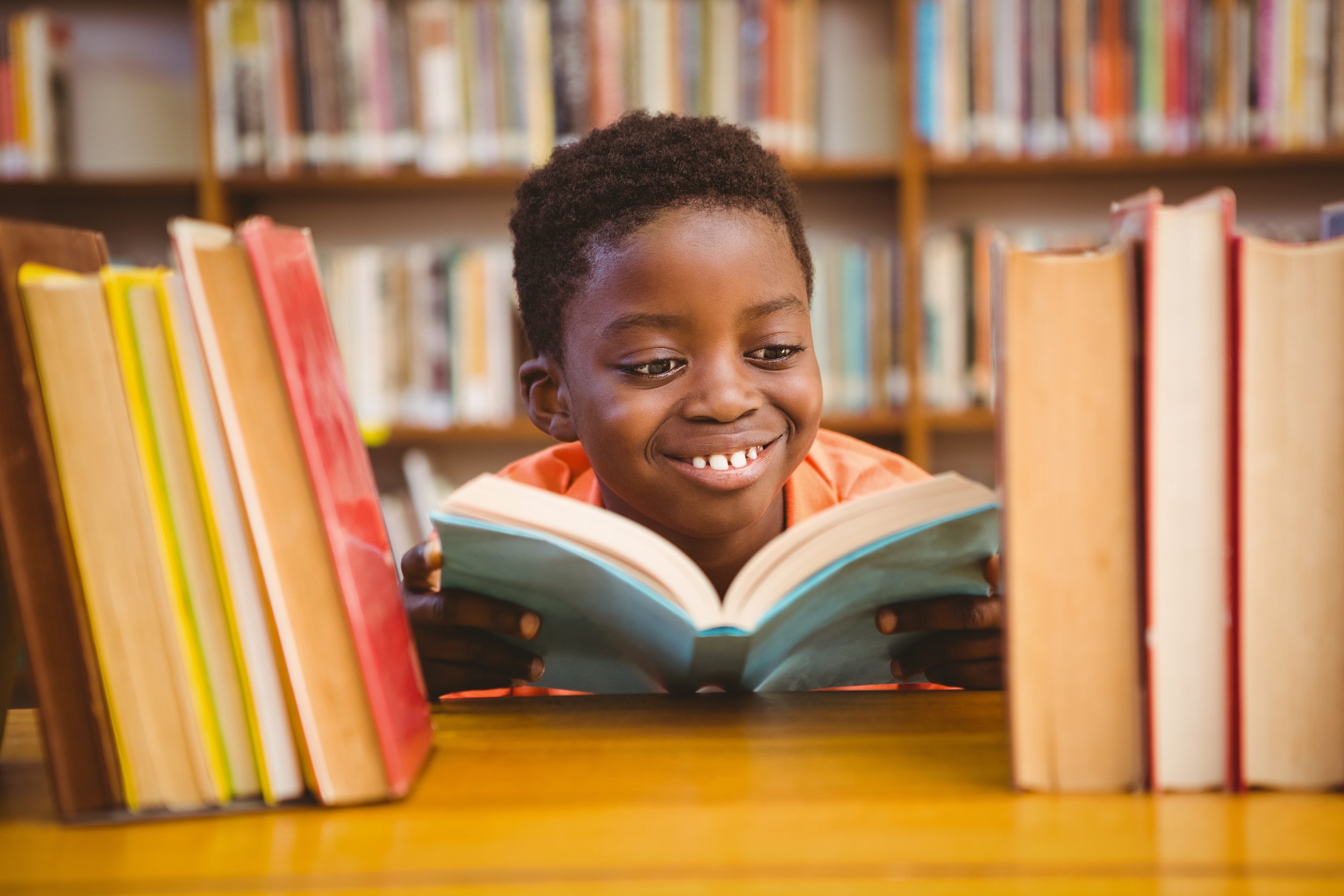 Cute boy reading book in library