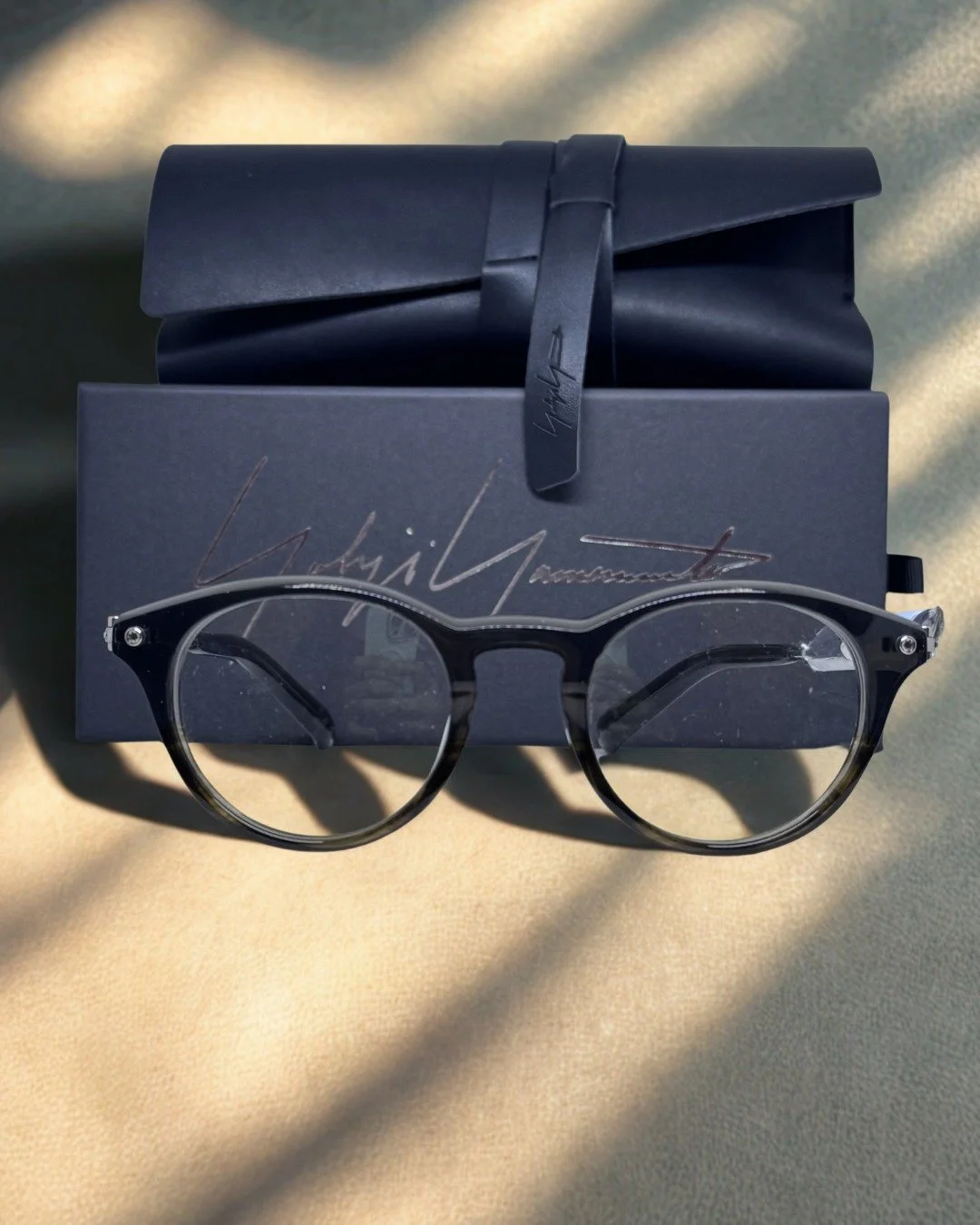 This is what buying Yohji Yamamoto actually looks like.

The round combination frame &mdash; tortoise acetate temple, silver rivets, the kind of construction that holds its shape for years rather than seasons.

The leather roll case &mdash; @yohjiyam