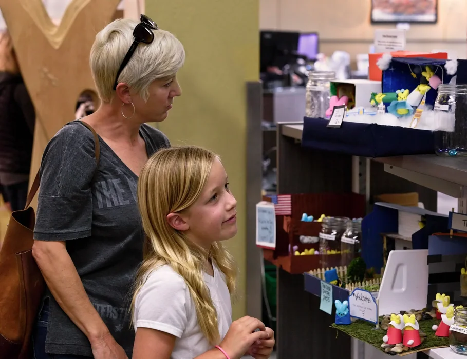 Napa County Library visitors Mandy (mother) and Ruby Kreps (9) take a few moments to look over all PEEPs diorama selections before voting. Ruby, tasked with a school project to do during Easter break, was in the library hunting for books about the blue-ringed octopus.