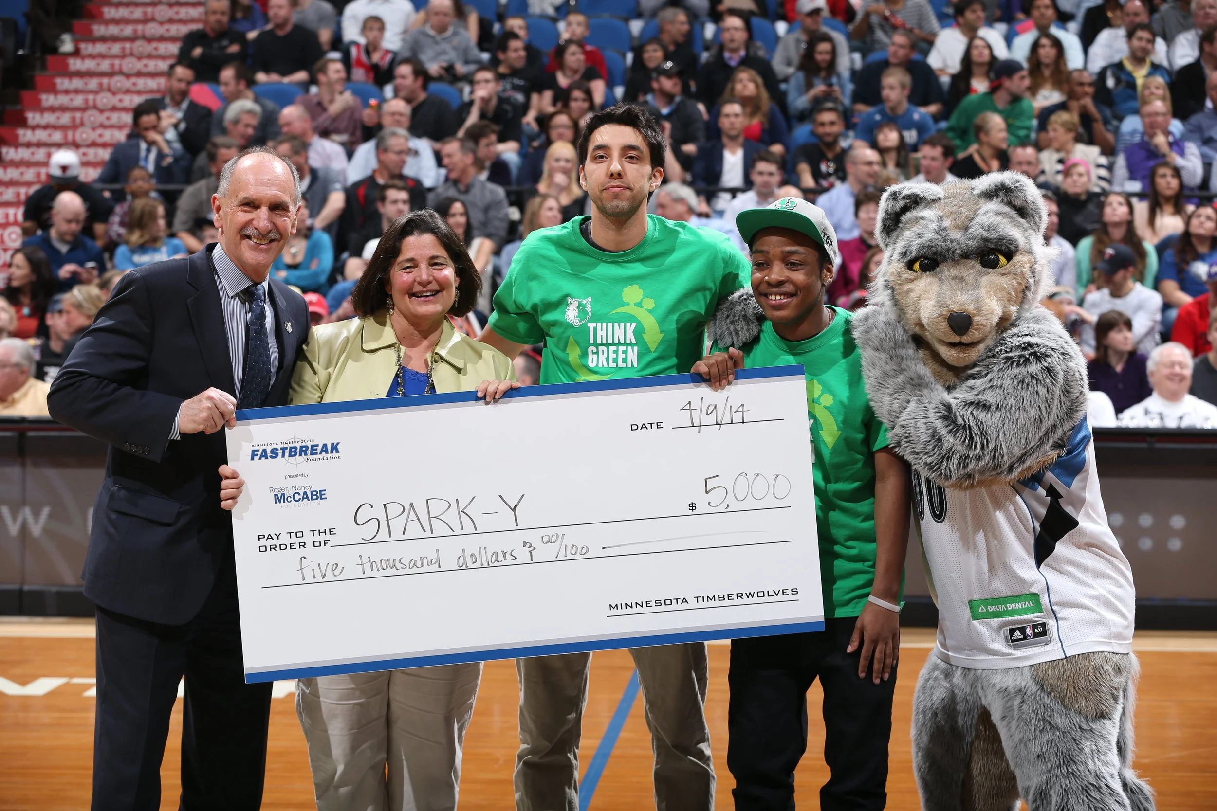 Mary Helen Franze and Zach Robinson receive grant at half court during a Timberwolves game in 2014.
