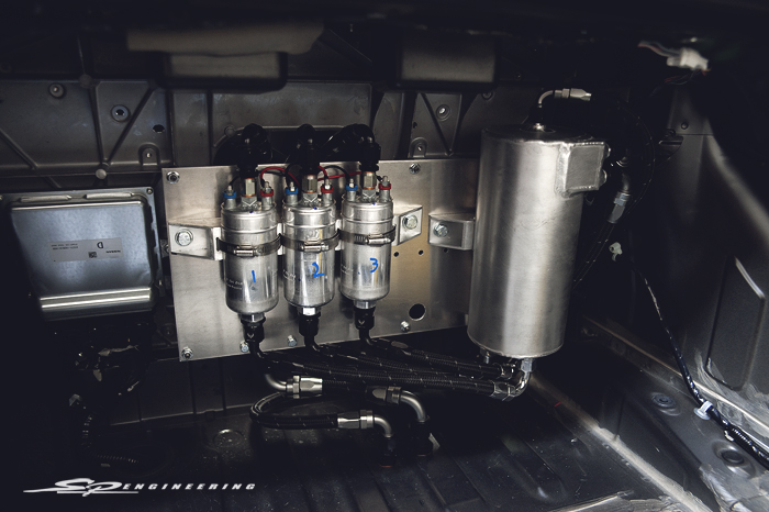 Our SPE custom triple fuel pump looking beautiful as always. Our custom triple fuel pump assembly houses a total of 5 fuel pumps (2 in the factory gas tank and 3 mounted on the panel). When fired up, fuel is sent up from the gas tank to the cylinder. From there, the fuel is sent to the triple pump assembly and ran down through the lines tailored to the front of the vehicle to the engine and cycled back for never ending fuel starvation during erratic driving.