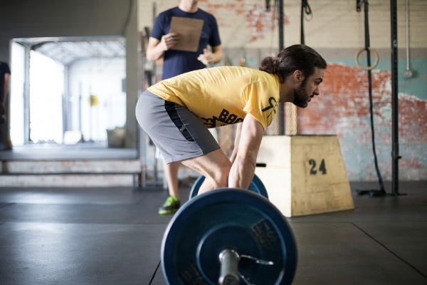 A long legged, taller lifter commencing a traditional Deadlift. You can see the lumbar spine is slightly flexed, and not in its neutral or strongest position.