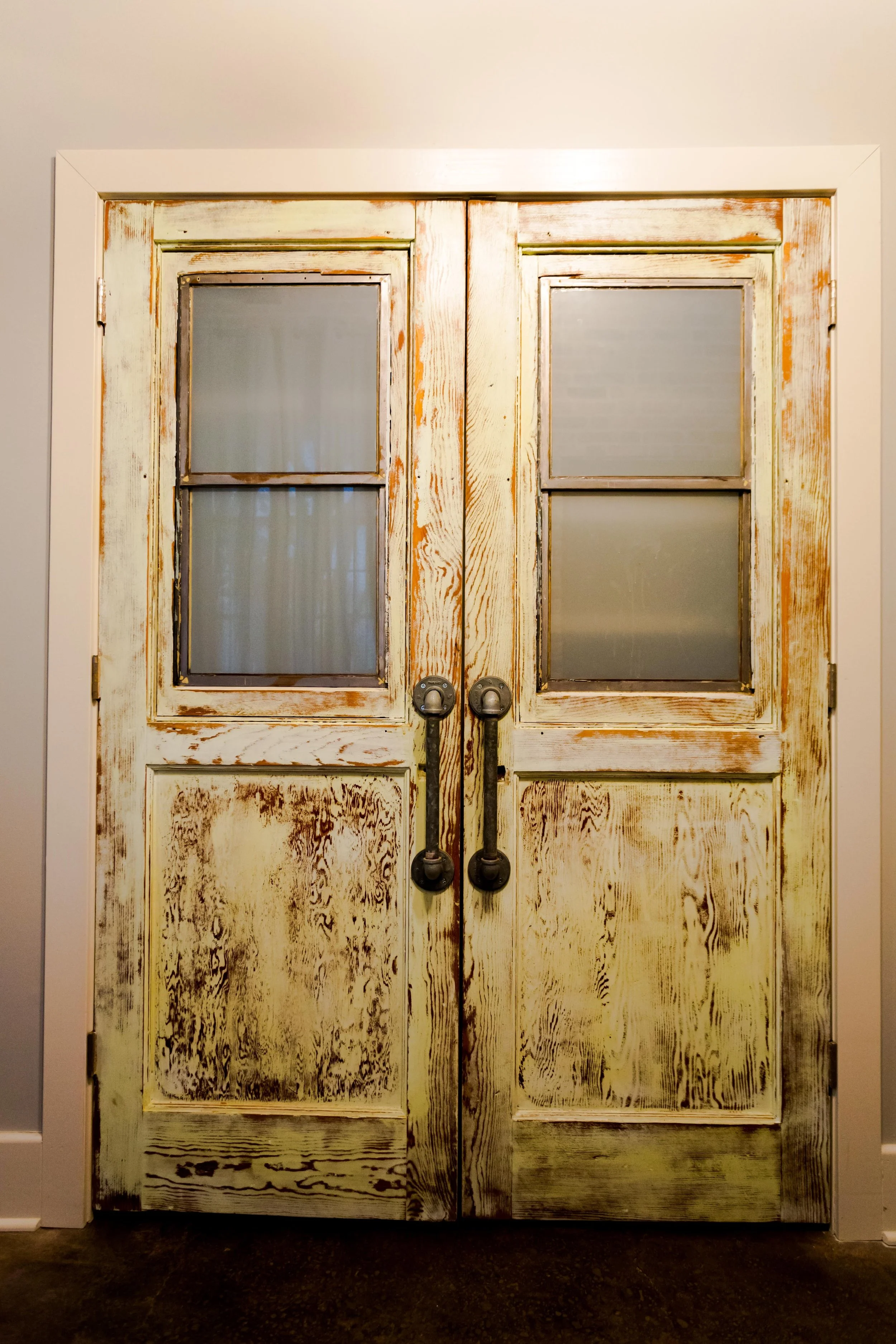 Salvaged door with pipe fittings for handles