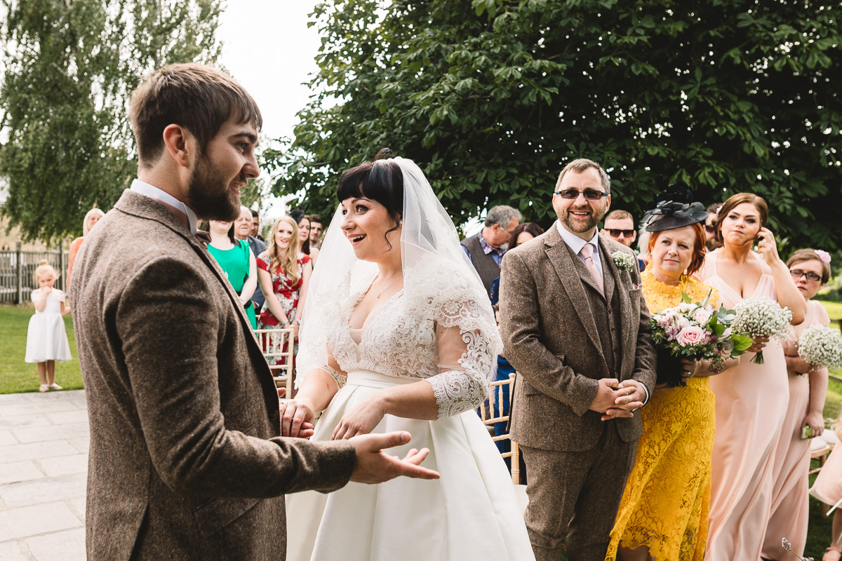 Fun moment during vows at outdoor hyde barn wedding ceremony