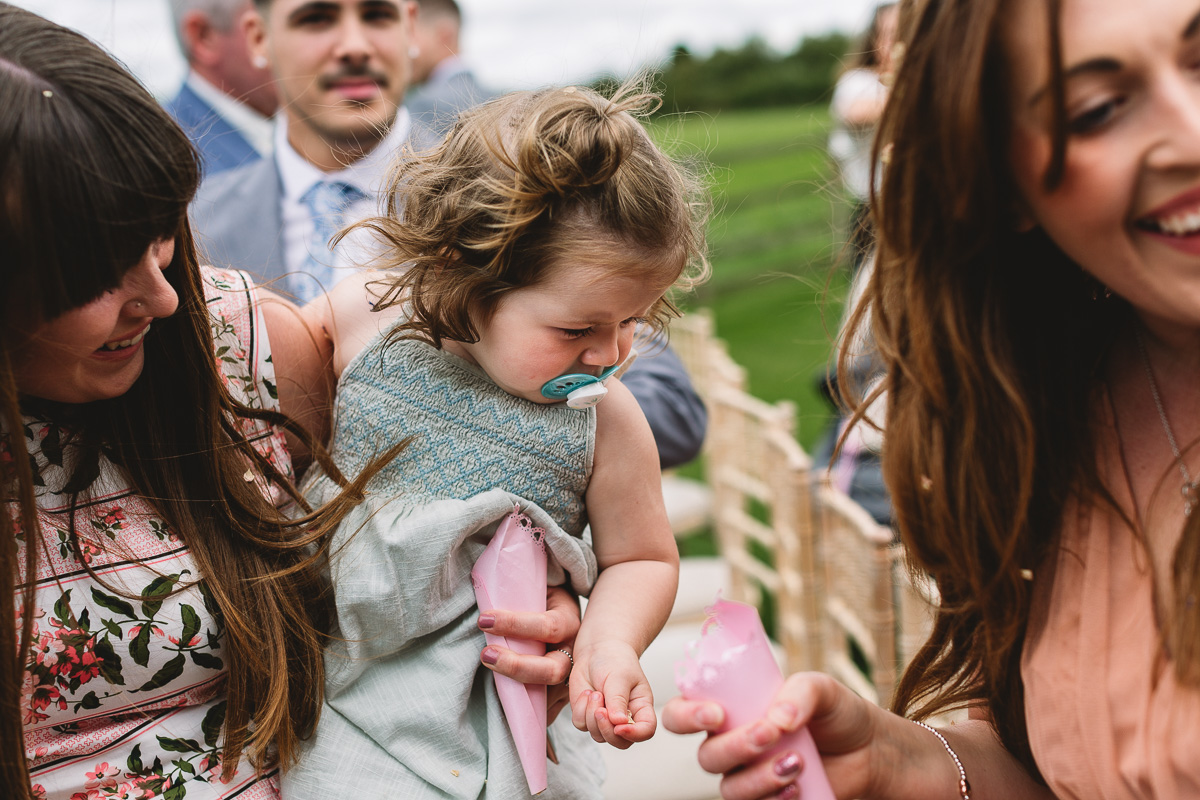 Child at wedding holds confetti | Candid Wedding Photos at Hyde Barn