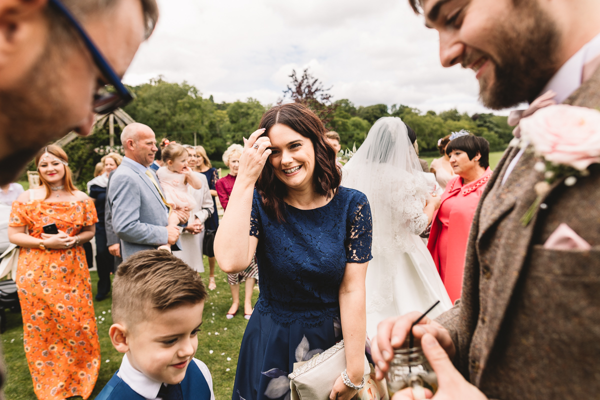 Woman in blue dress smiles after outdoor wedding ceremony at Hyde Barn