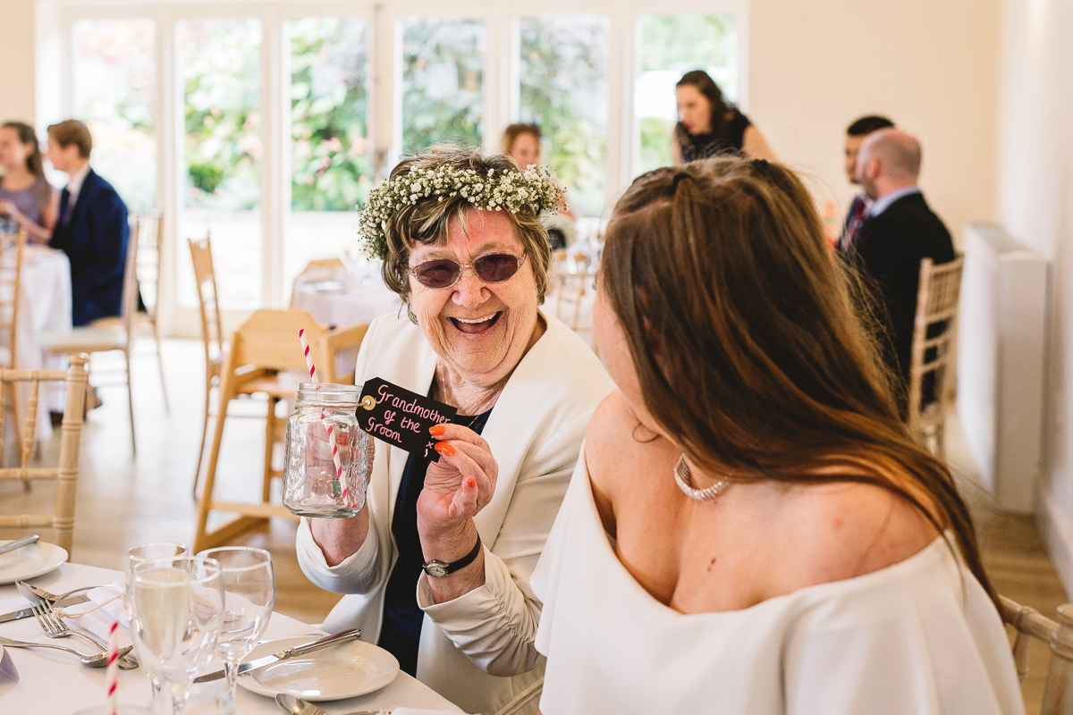 Grandmother with flower crown holds up fun vintage glass tumbler with her name card