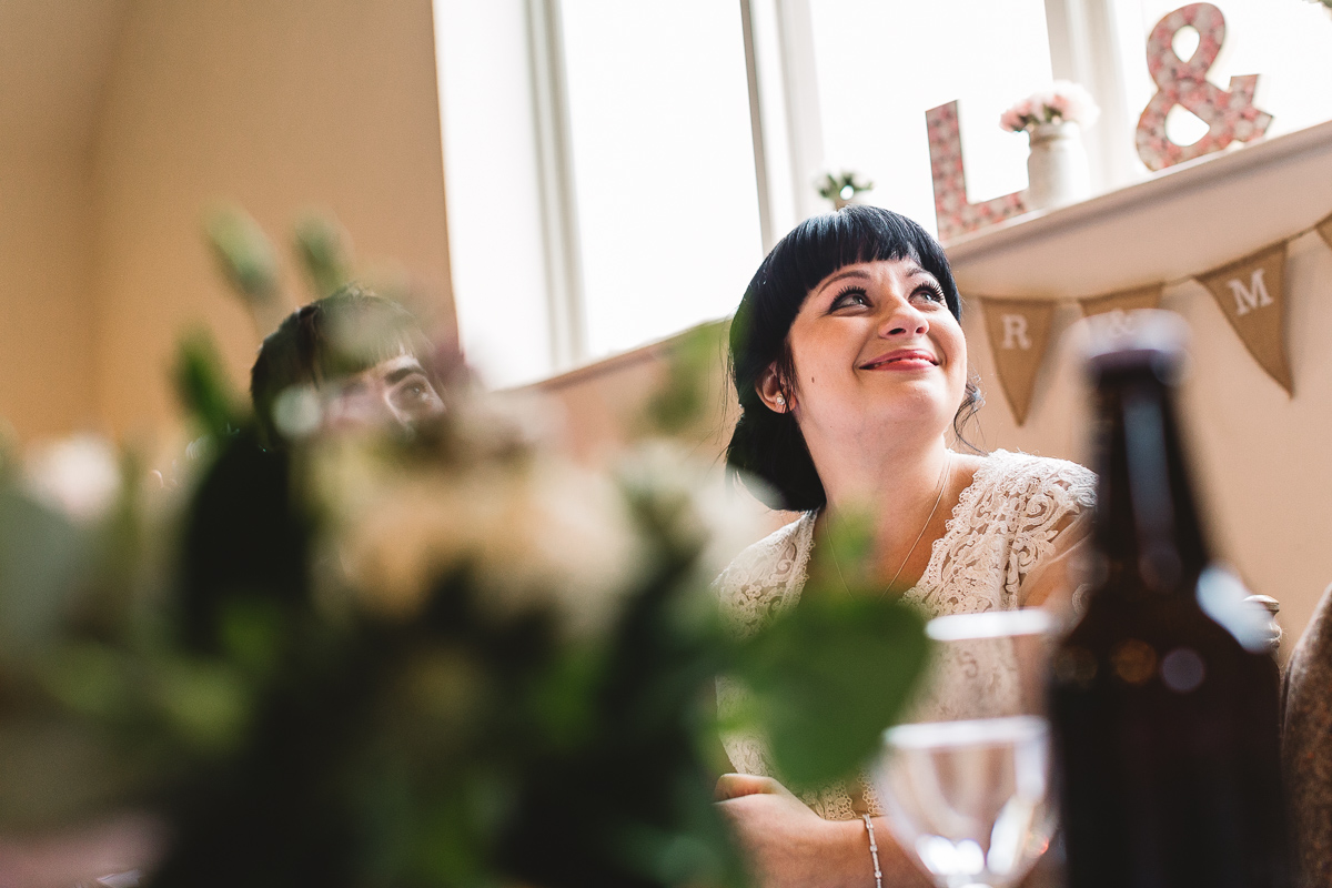 Happy bride smiles at her dads funny wedding speech at hyde barn