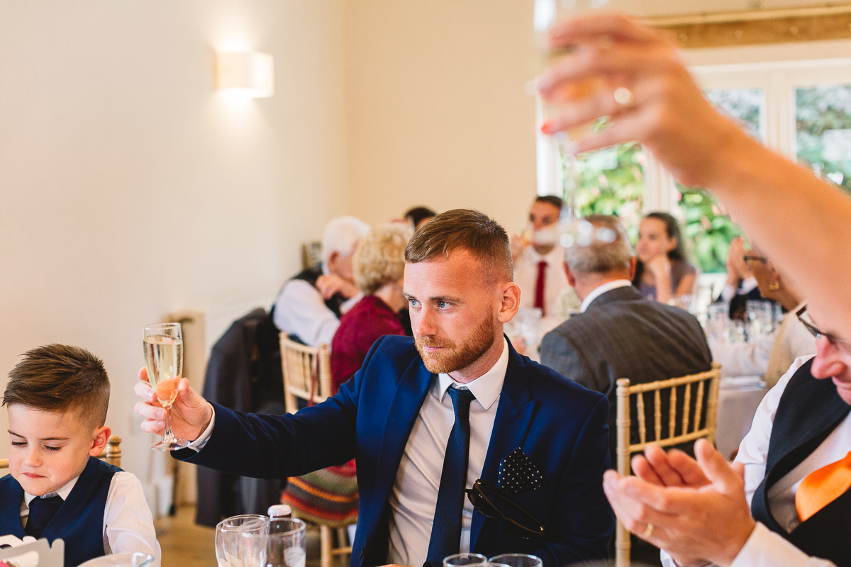 Cheers with prosecco at fun hyde barn wedding