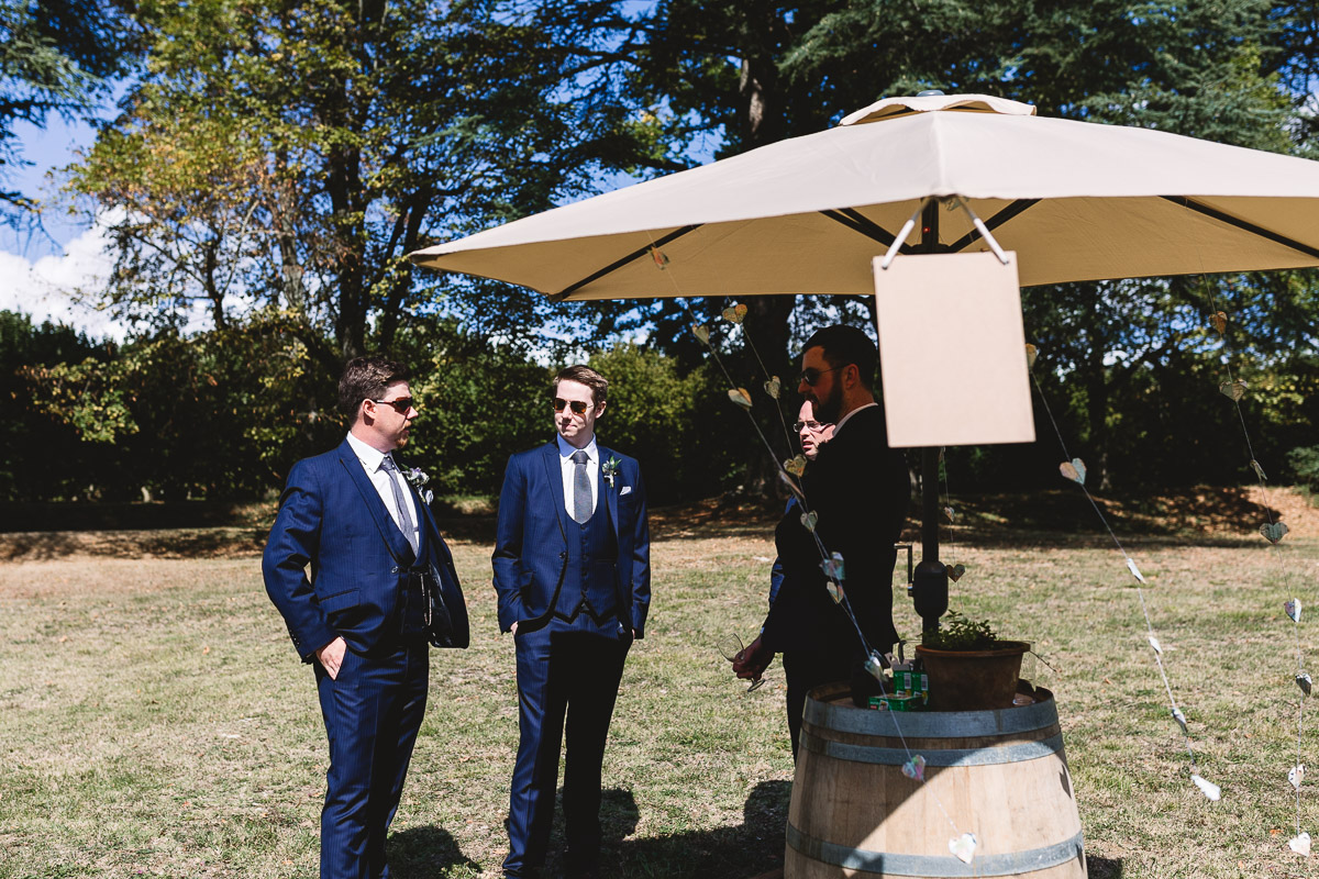 Candid photo of groomsmen on lawn at france destination wedding