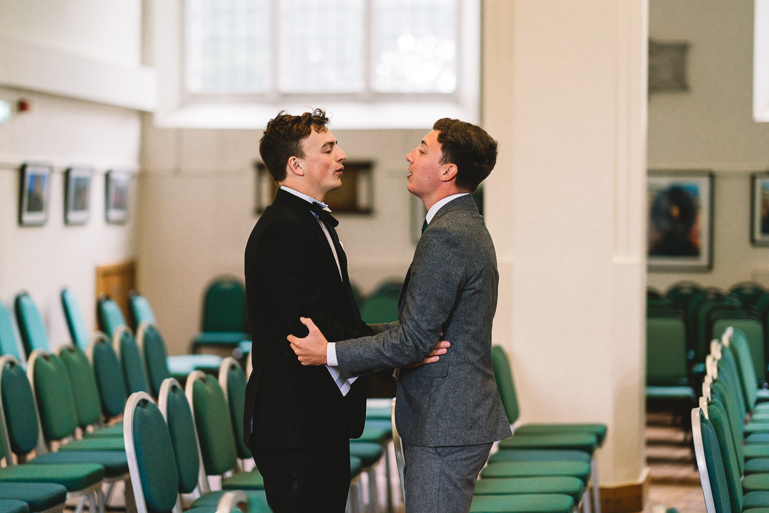 Photo inside of wedding venue of the Groom doing breathing exercises with one of his Groomsmen to calm the nerves before the wedding ceremony