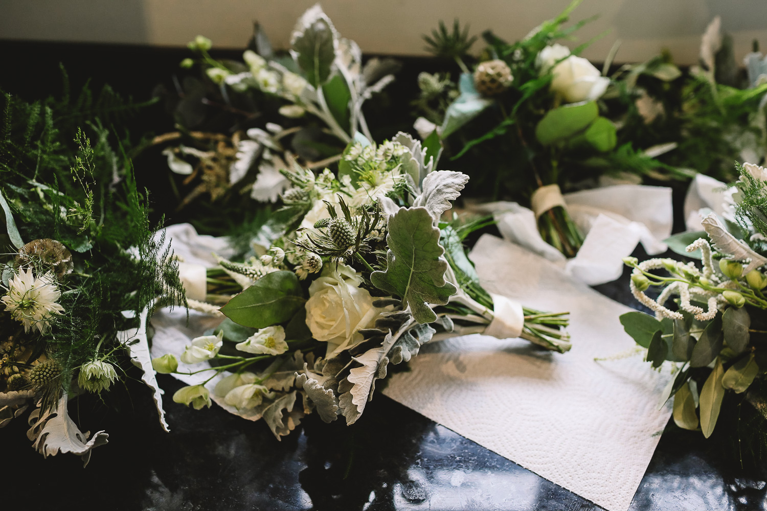 Photo of bridesmaid bouquets with roses and green foliage drying on the side at relaxed Sheffield wedding