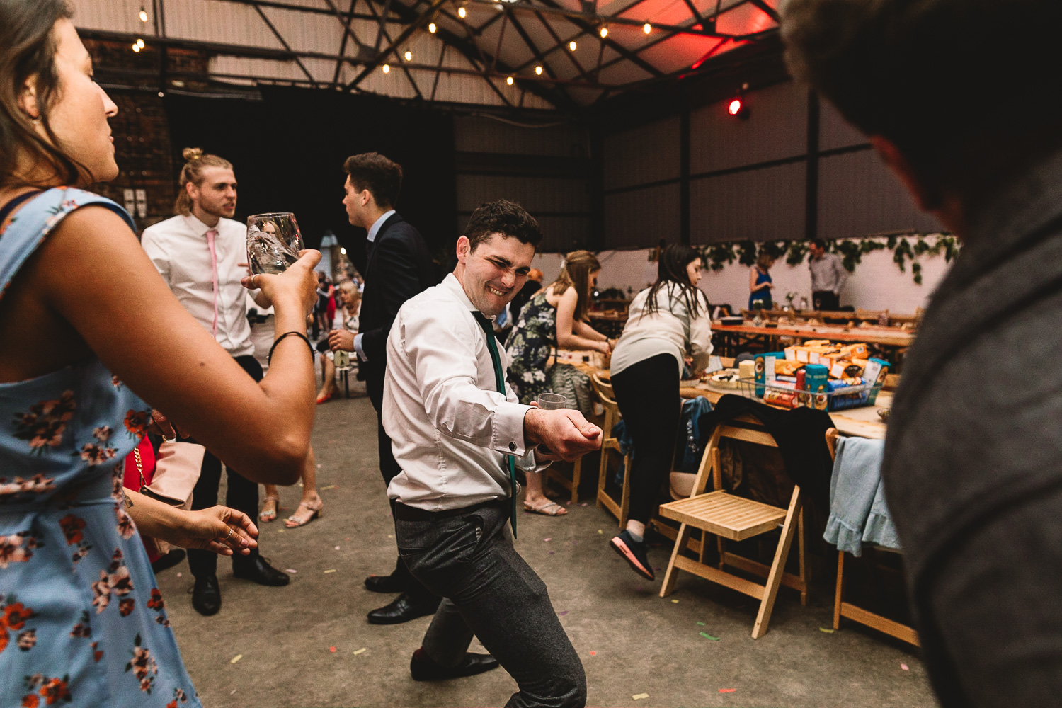 Guest dancing doing a pulling move to another guest on fun dance floor at alternative warehouse wedding venue 92 burton road