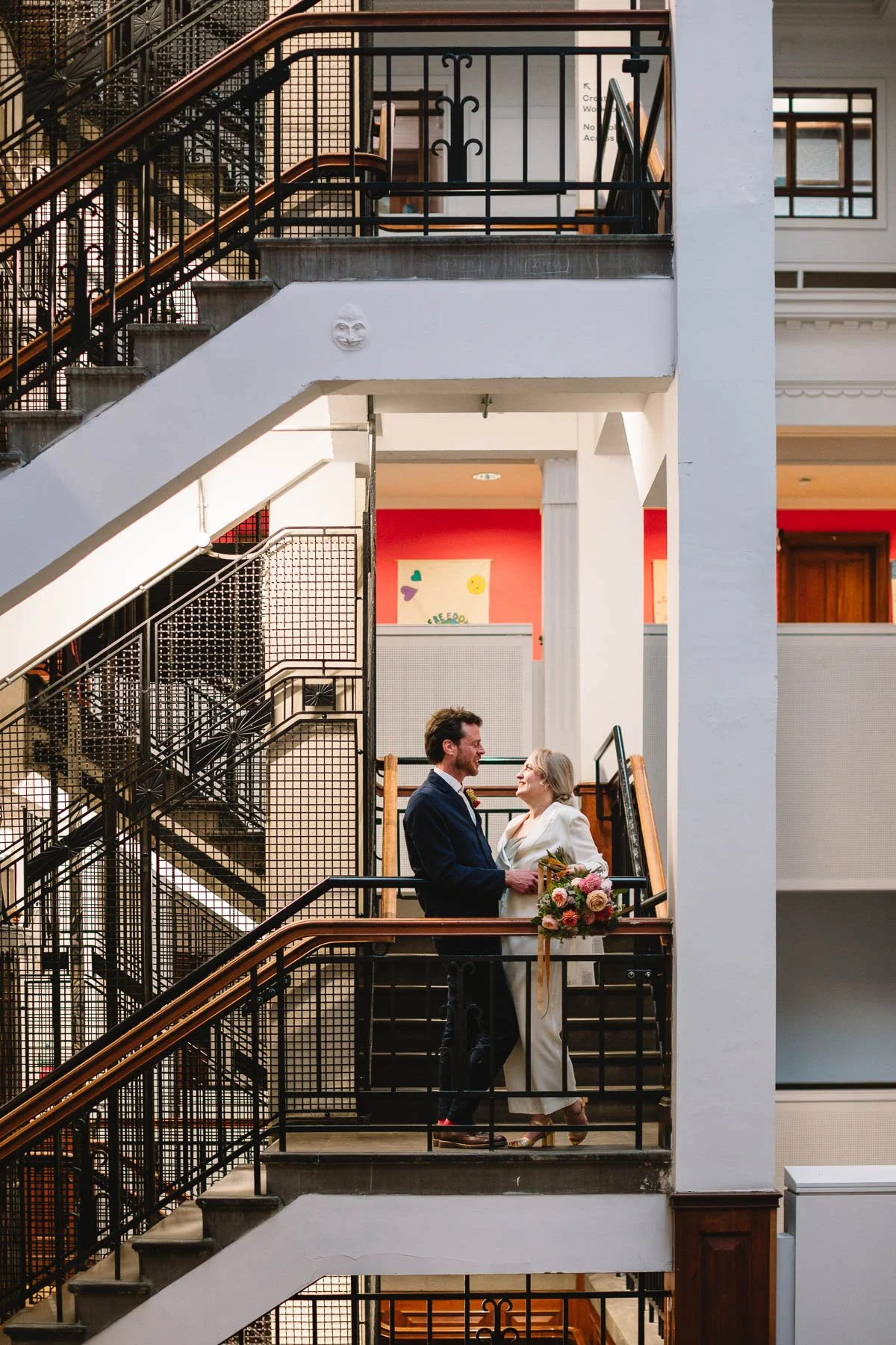 Newlyweds laughing together on the staircase inside The Tetley during their Leeds wedding