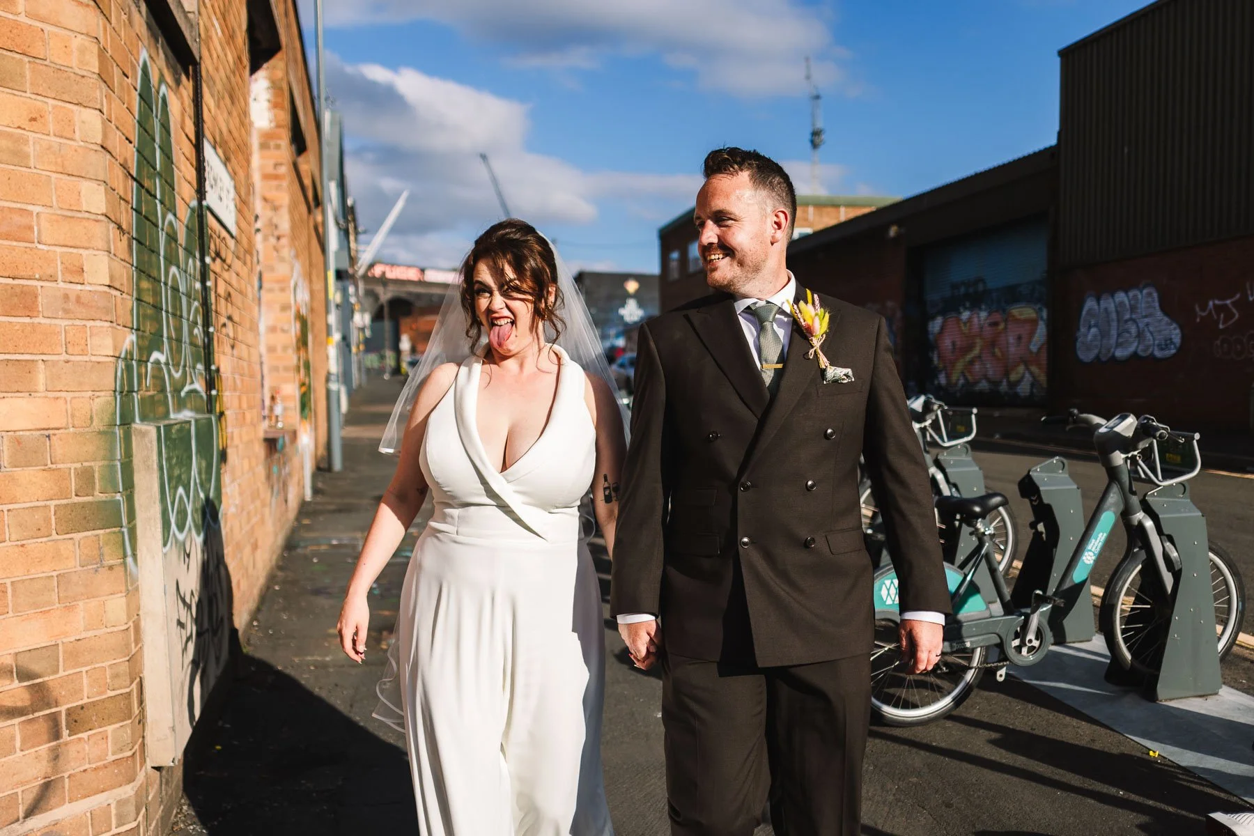 Bride and groom laughing together while walking through Digbeth during their Birmingham wedding