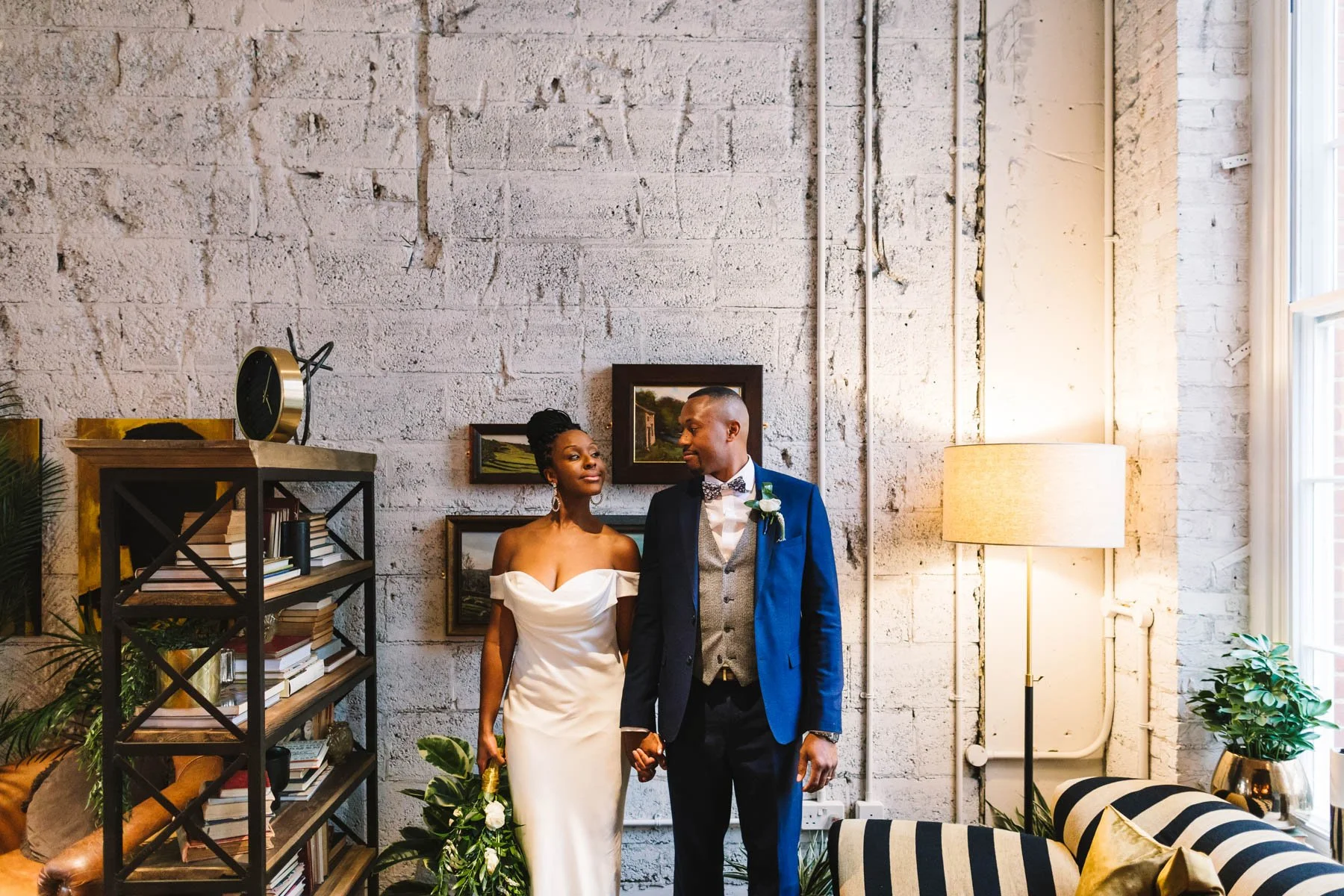 Newlyweds holding hands and looking at each other during relaxed indoor wedding photos