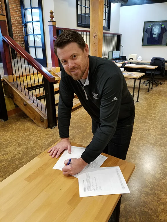 Devin signing Colvos' first project contract early this year. 