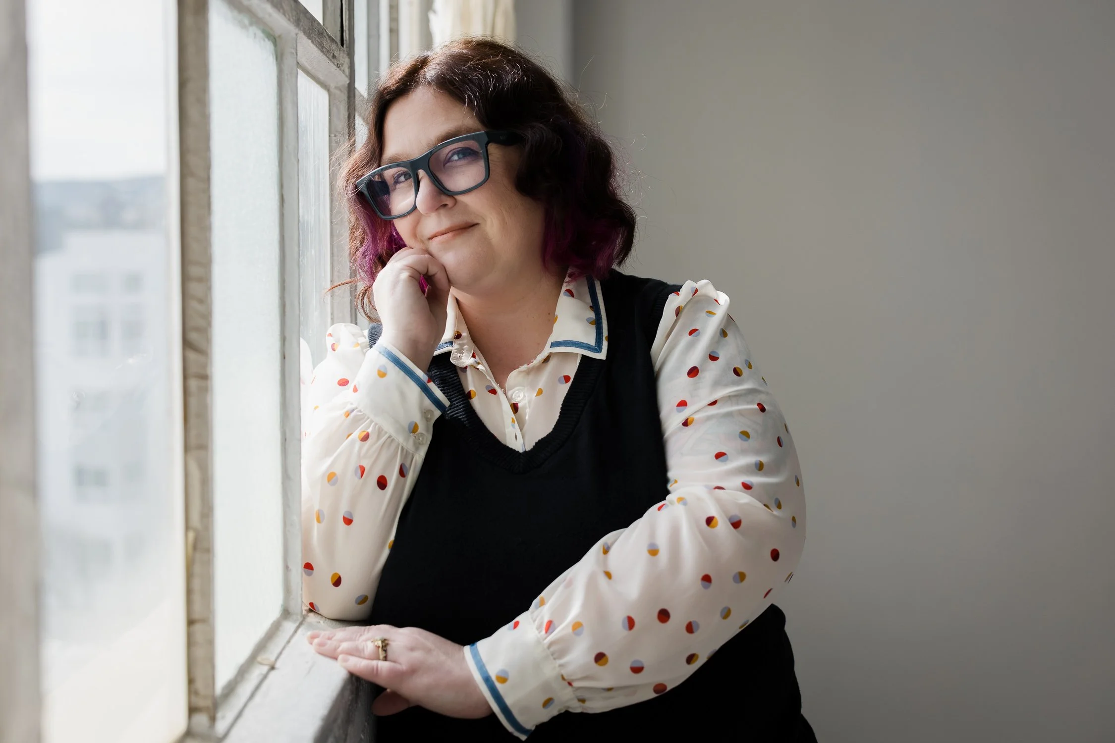 Author Kate Wilder smiling by window in natural light, San Francisco brand photographer portrait session