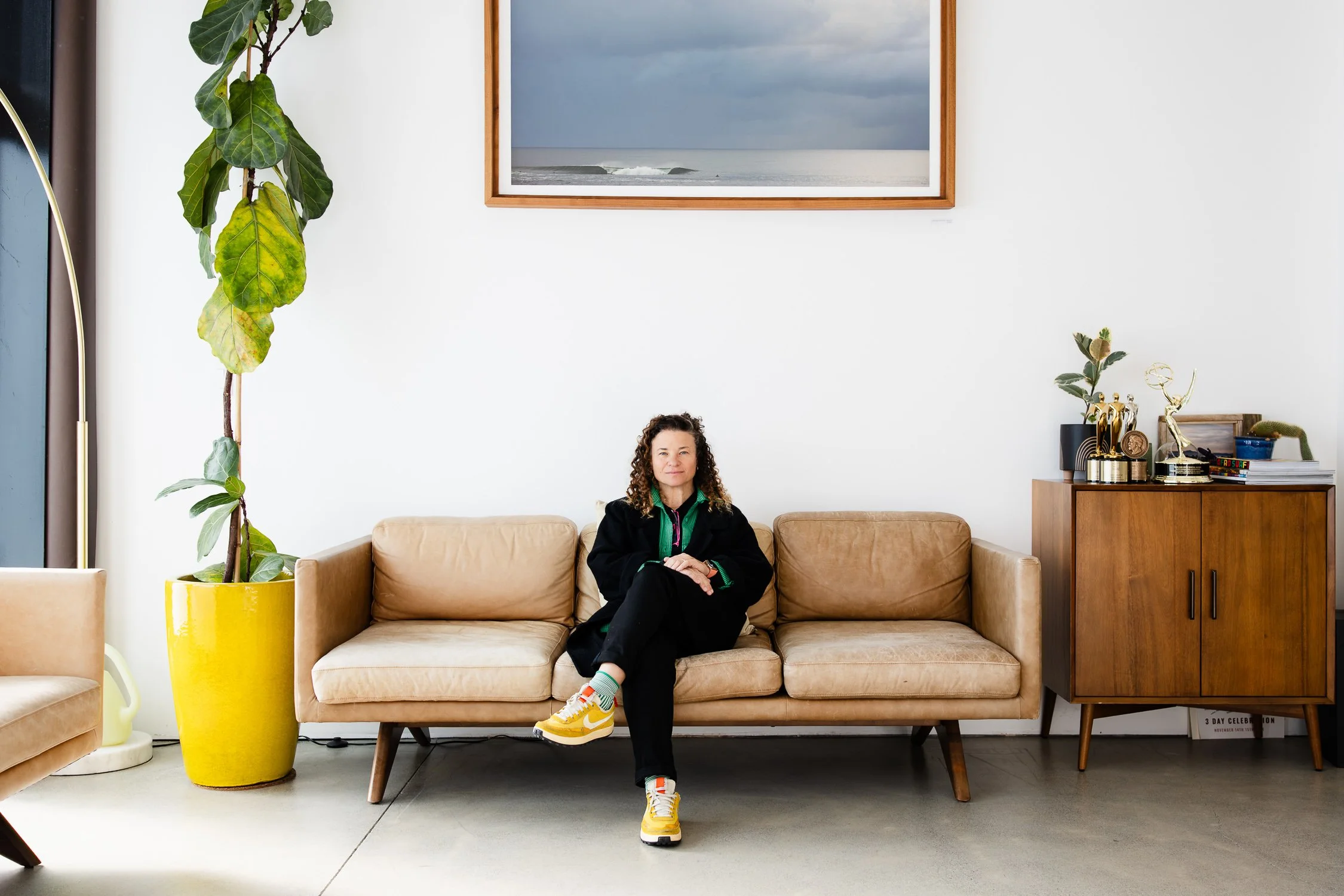 Film producer Dalia Burde seated on couch in sunlit studio, San Francisco brand photographer environmental portrait