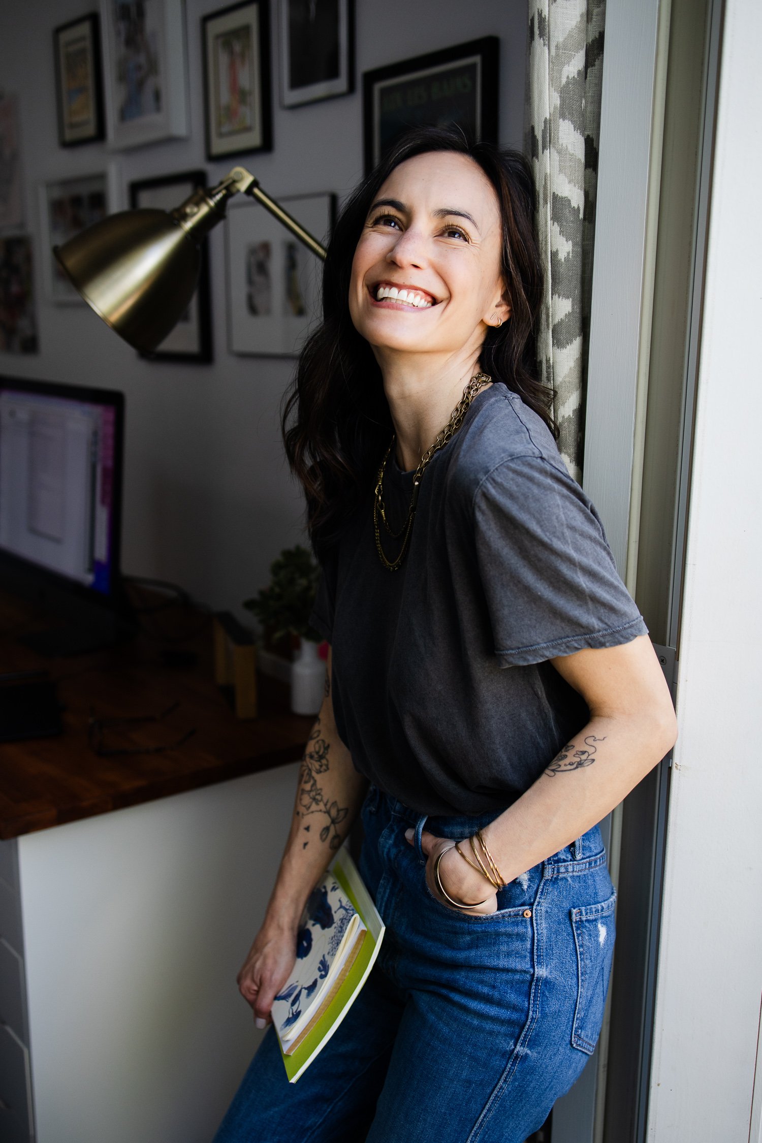 San Francisco brand photography portrait of a web designer standing in her workspace holding a book.