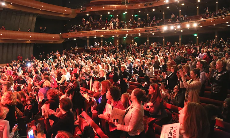 Hundreds of women watch and cheer for the keynote speaker at the 2015 Women Grow Leadership Summit