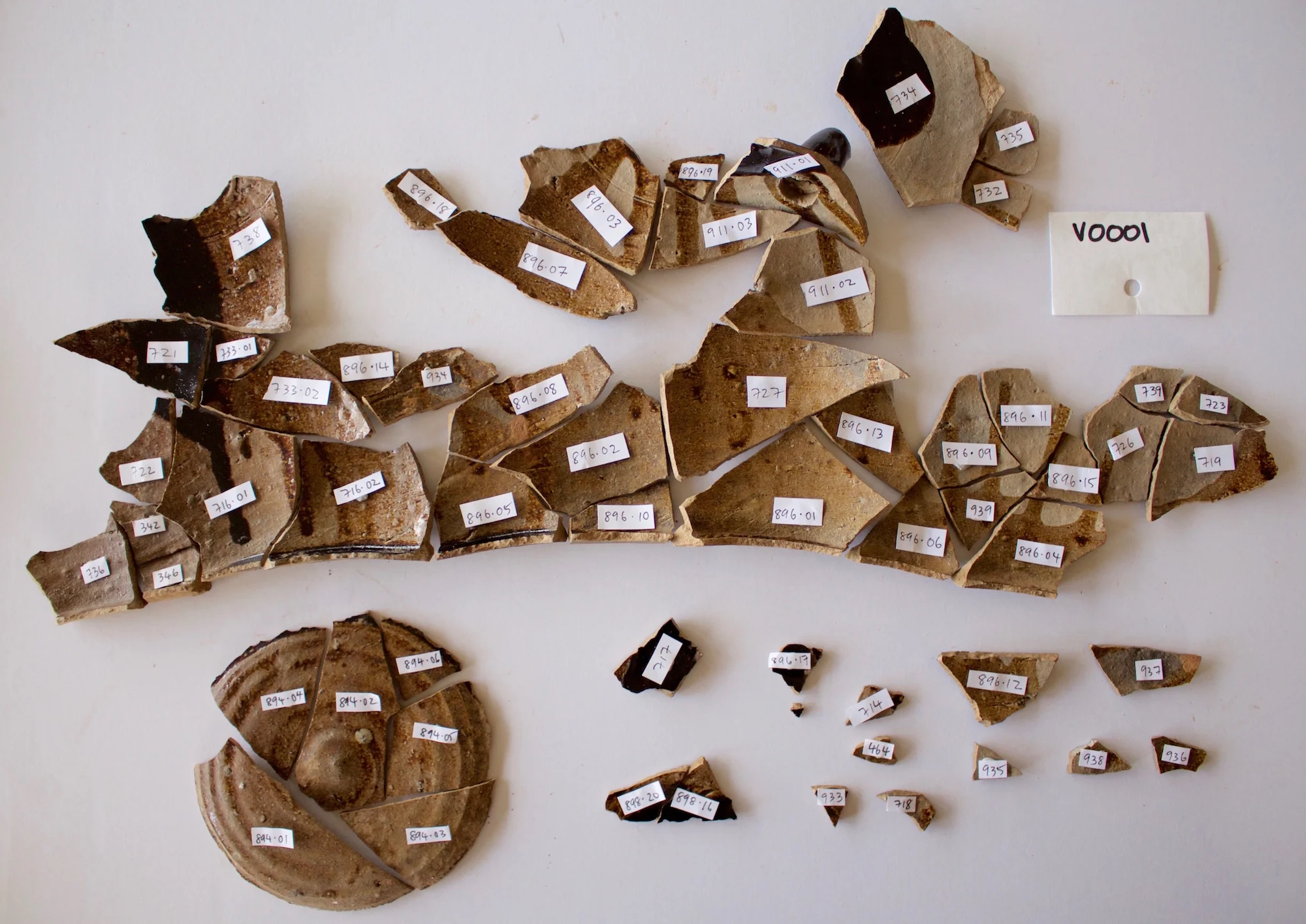 The round section at the bottom left of the photograph was the base of the jar, about 12cm in diameter. The spout is at the top right of the photograph. The fragments show that the interior of the jar was only lightly glazed during its manufacture, and that the glaze liquid was only roughly poured into the jar - you can still see the drips of liquid (photo: Paul Macgregor)