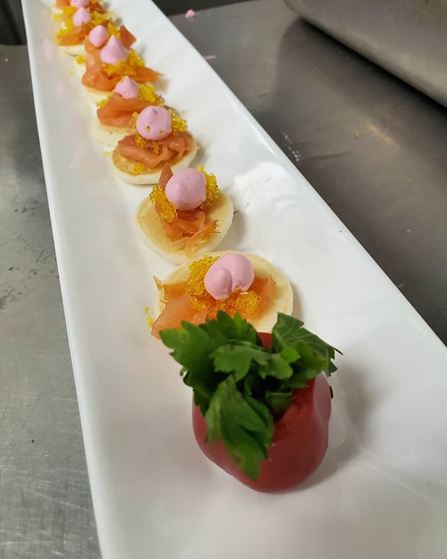 Smoked salmon with blinis topped with you tobiko and beets creme fraiche